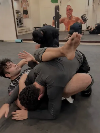 A dynamic scramble on the mat during a No-Gi roll. Both grapplers fight for a dominant position, showcasing the agility and adaptability required in jiu-jitsu.