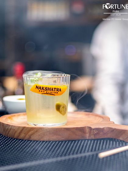 Our signature Nakshatra cocktail, infused with smoke and garnished for a dramatic presentation. It's a drink that's as memorable as the view.