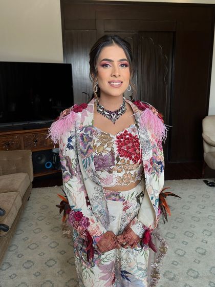 The bride looking happy and stylish, her floral ponytail perfectly matching her vibrant Varun Bahl outfit.