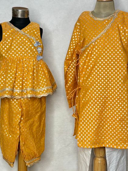 A closer look at the details of this matching yellow brocade set. The wrap-style top for the girl and the side-tie kurta for the boy are both designed for comfort and style.
