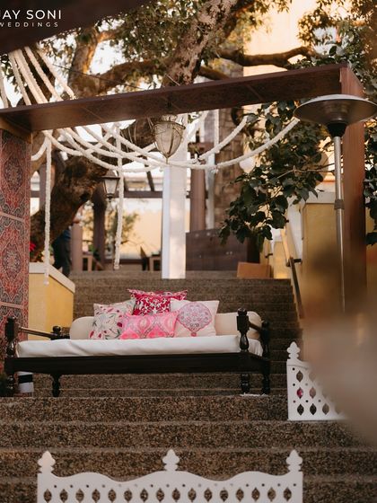 A traditional Indian diwan placed on the steps, offering a more structured seating option within the unique tiered lounge design.