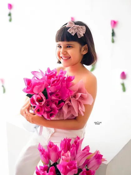 A candid moment of pure joy, holding a bouquet of bright pink tulips.