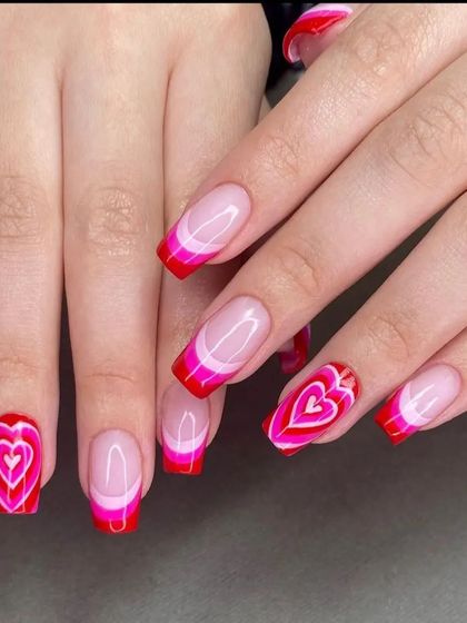 A fun and playful Valentine's Day design with red and pink French tips and layered heart art on the accent nails.