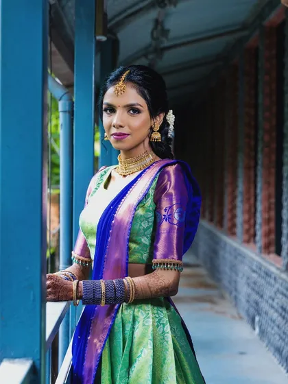 A full-length view of the colorful engagement look. The half-saree is a fun and modern choice, and the makeup is designed to be equally celebratory.