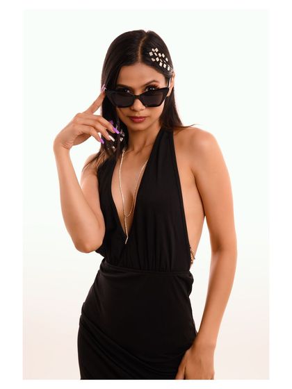 A close-up shot with the model adjusting her sunglasses, creating a classic, movie-star-inspired look.