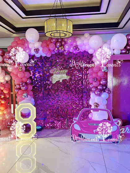 Another view of the fabulous Barbie party decor, showing the shimmering pink backdrop and balloon arch that create a picture-perfect setting for an 8th birthday.