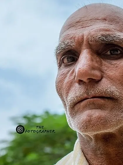 This is another angle from the same street portrait session. The slightly off-center composition and the soft background help to emphasize his weathered features and steady gaze.