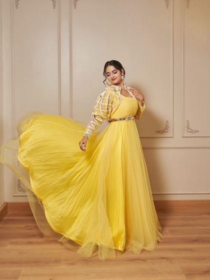 Meet 'Jauna', the perfect haldi outfit. This vibrant yellow gown is paired with a stunning jacket featuring intricate threadwork and puffed sleeves.