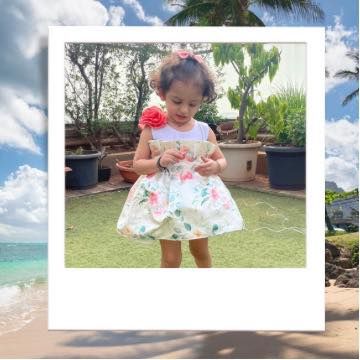 Happy smiles for happy girls. This little client is enjoying a sunny day in her floral dress, a perfect outfit for everyday charm.