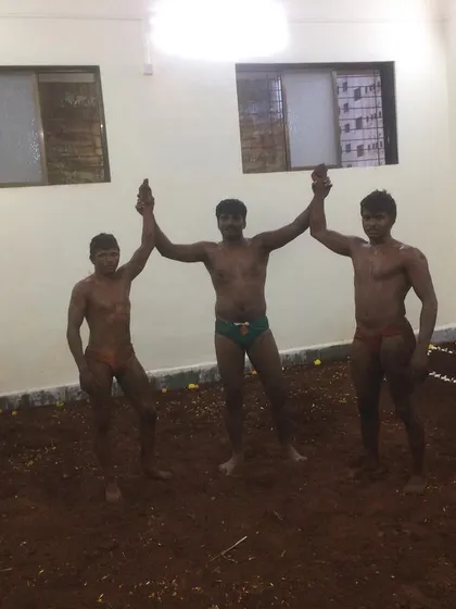 Victory in the akhada. A referee raises the hands of the winners after a friendly bout during the inauguration of our mud pit, celebrating the spirit of sportsmanship.