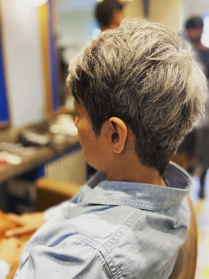 The back and side view of this silver pixie cut shows the detailed layering work. This technique ensures the hair has volume and sits perfectly without a lot of effort.