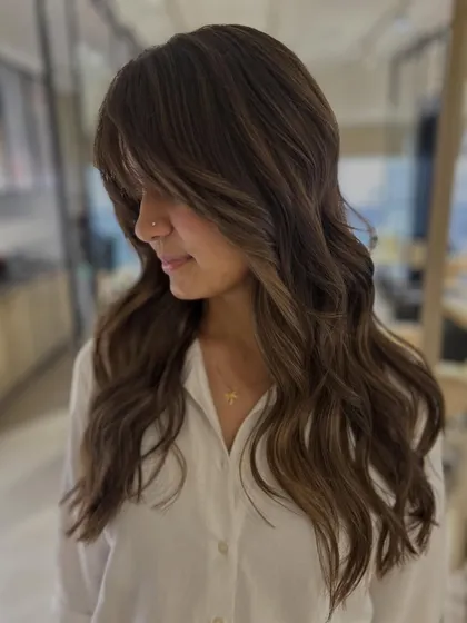 For this client's first time coloring her hair, we chose a three-tone blend without bleach. I added face-framing layers and bangs to create a soft, flattering shape.