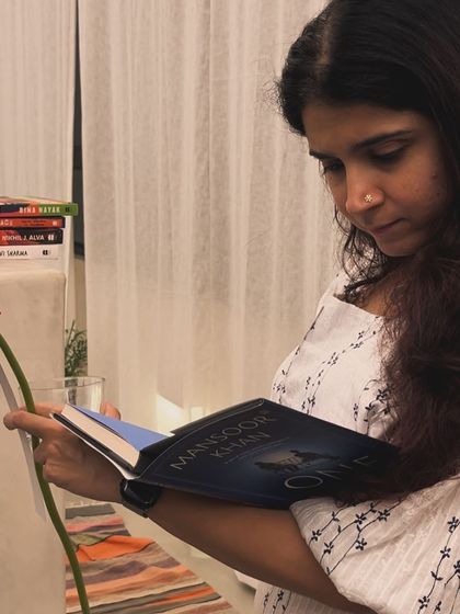 A reader enjoying a quiet moment with a new book and a flower from our decor. It’s the little details that make these events special.