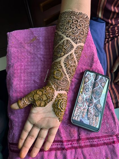 The palm-side view of this designer engagement mehendi. The pattern is elegant and modern.