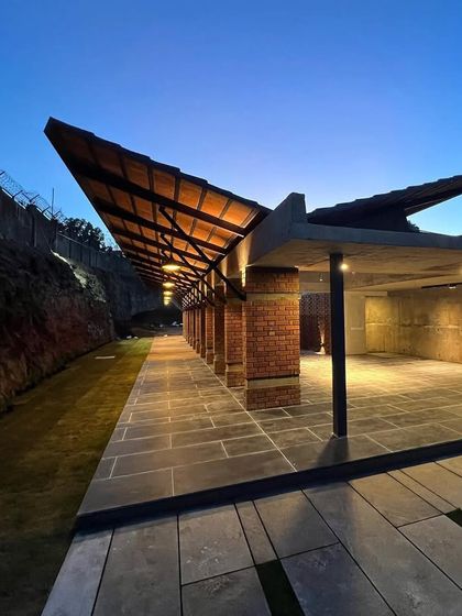 The clubhouse for "The Cove" community, seen at dusk. The building's angular roofline and warm lighting create an inviting atmosphere for residents.