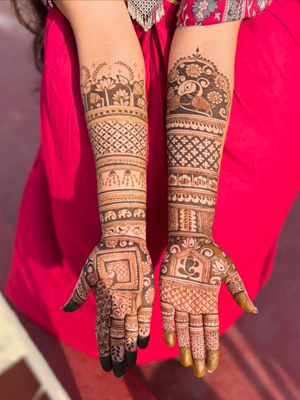 This bridal design is rich with symbolism, featuring Ganesha, elephants, and a kalash, along with lotus motifs on the forearm.
