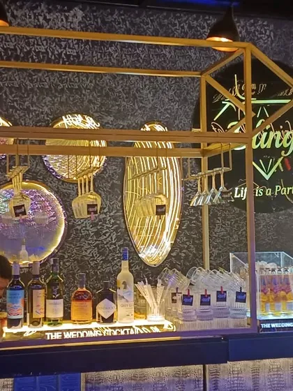 A modern and chic bar setup with gold accents and unique decorative plates. The bar is stocked with a premium selection of spirits for crafting quality cocktails.