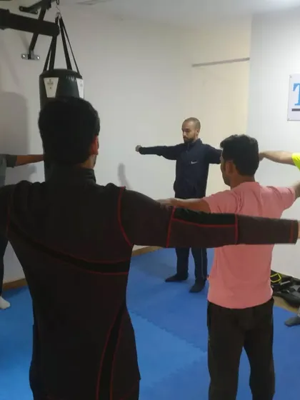 Here, I am leading a group of shooters through specific warm-up drills. These sessions are designed to improve posture and muscle engagement, which are fundamental for maintaining a stable shooting stance over long periods.