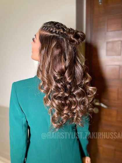 A fun and trendy half-up style with two small top knots and cascading curls. This look is perfect for a modern Sangeet or cocktail party, combining playfulness with glamour.