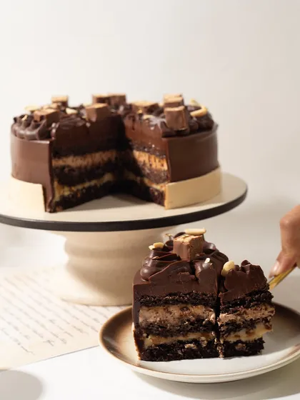 A slice of our Snickers Cake shows exactly what we're about: pure indulgence. We layer rich chocolate cake, gooey caramel, and roasted peanuts to create something truly extraordinary. This is the quality you can expect in all our celebration cakes.