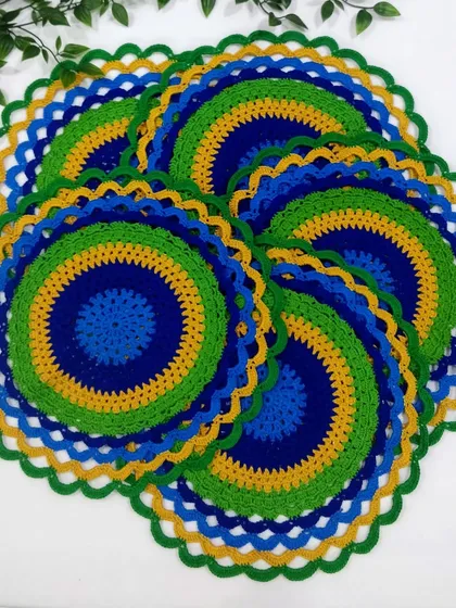 A set of six peacock placemats spread out, showing how they look as a complete dining set. The colors are so lively and eye-catching.