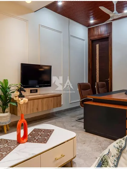 This angle highlights the room's multi-functionality, with a comfortable lounge area and a wall-mounted television for breaks or informal presentations. The space is designed to be both a productive office and a relaxing retreat.