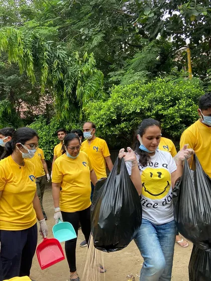 Members of our community carrying bags of collected trash, demonstrating their commitment to a cleaner environment.
