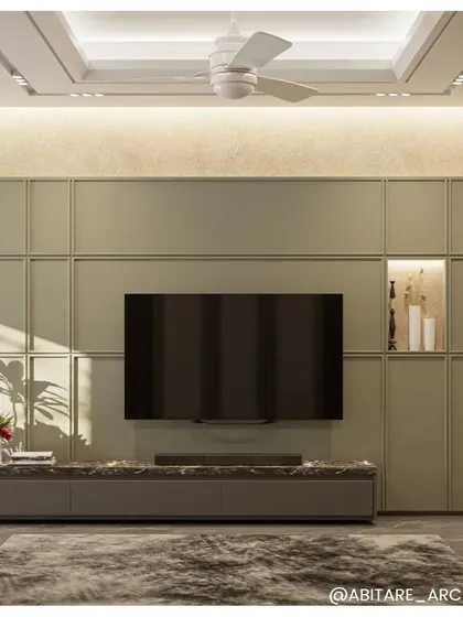 This television and media unit is designed to be both functional and a beautiful feature of the room. The soft green paneling, marble countertop, and integrated backlighting create a clean, organized, and aesthetically pleasing focal point.