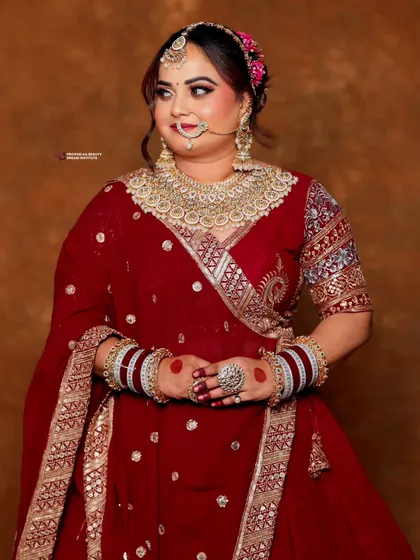This full-length shot captures the grandeur of the bridal outfit. The makeup is designed to stand out and complement even the most elaborate wedding attire.
