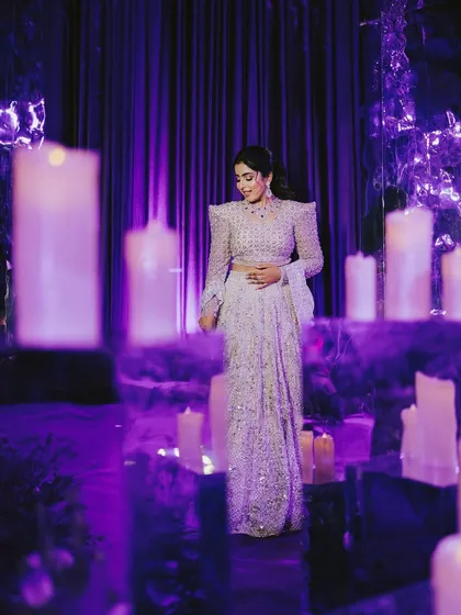 The bride, surrounded by candles and ethereal purple light, looks absolutely magical. This portrait captures the enchanting atmosphere of her reception.