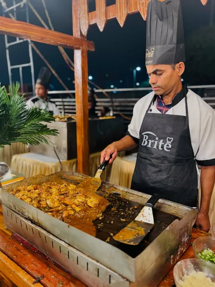 A chef at the live Prawns Teppanyaki station, grilling prawns to perfection on a hot flat-top griddle.
