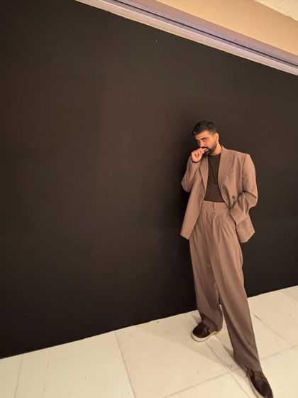 A candid moment from the same event. The all-black background really makes the silhouette of the suit stand out.