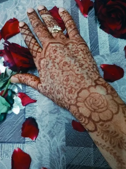 A beautiful shot of a faded floral henna stain, surrounded by rose petals.