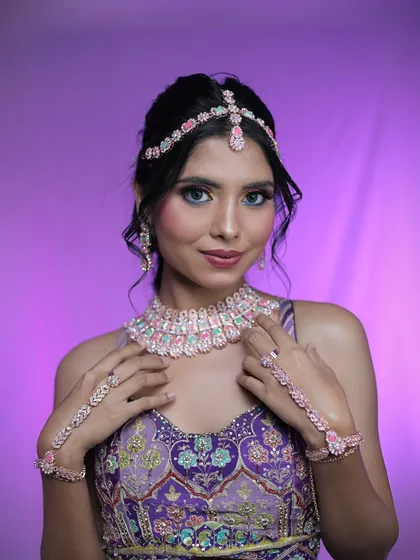 A close-up of the model showcasing the colorful eye makeup and diamond jewelry.