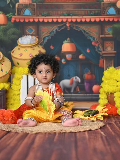 A candid shot of a toddler Krishna looking curiously at the props around him.