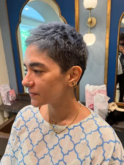 A bold haircut can be incredibly freeing. For this look, I went with a super short, textured ash-blue crop cut. It's an edgy, low-maintenance style that highlights her features perfectly.