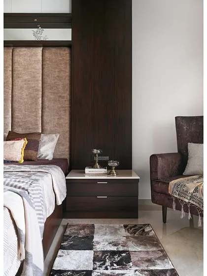 The side profile of the bed area shows the seamless integration of the bedside table with the extended wood paneling. This thoughtful design detail creates a clean, continuous line and enhances the room's custom feel.