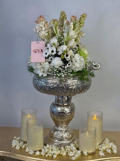 A straight-on view of the silver urli floral arrangement, a perfect centerpiece or welcome gift for Diwali and other traditional festivals.