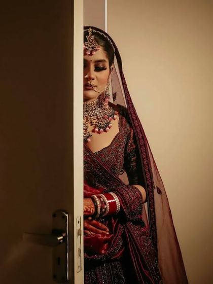 A creative bridal portrait, with the bride peeking from behind a door. This shot creates a sense of anticipation and mystery, adding an artistic touch to the bridal gallery.