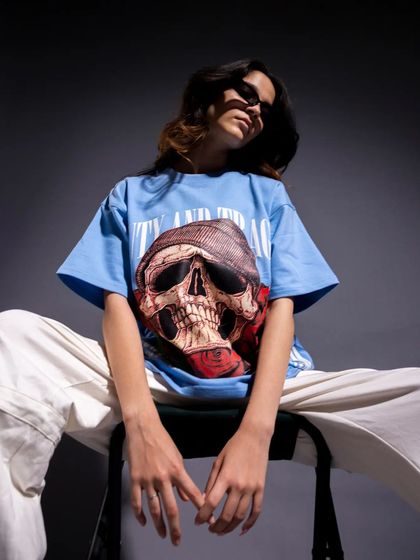 Another shot of the female model, this time in a blue graphic tee. The relaxed, seated pose and soft but directional light create a cool, laid-back vibe that is very appealing for streetwear brands.