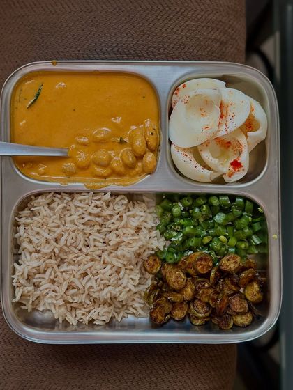 This plate combines brown rice with a fresh rajma curry, sautéed vegetables, and a side of boiled egg whites for an extra protein boost.