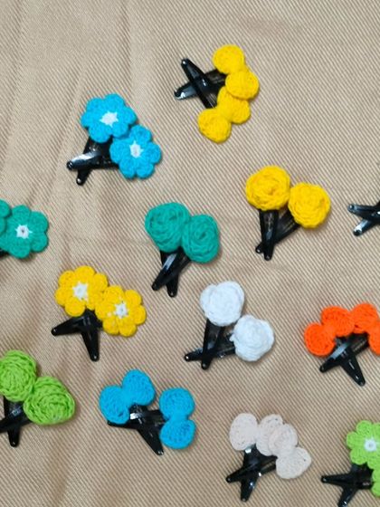 These are my little flower hair clips. I make them in pairs using many different colours of cotton yarn. They are simple, beautiful, and a lovely handmade addition to any girl's collection.