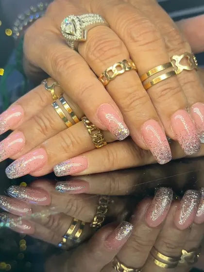 Another view of the sparkling pink and silver glitter ombre nails, styled with lots of rings.