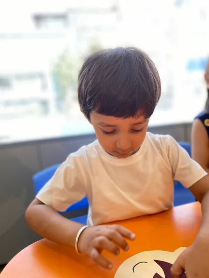 A moment of quiet concentration as a student works on his craft project.