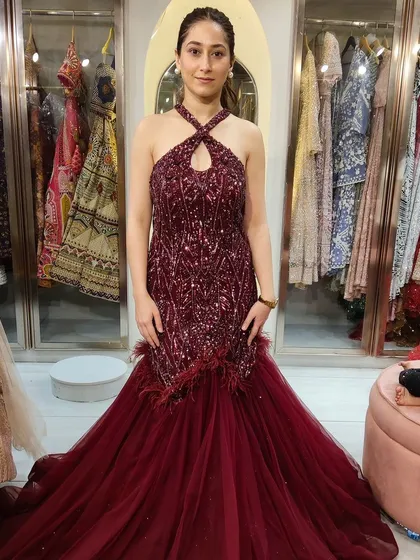 Here she is in another option, a deep maroon halter-neck fish-tail gown with feather details. Both are stunning choices for a cocktail or reception.
