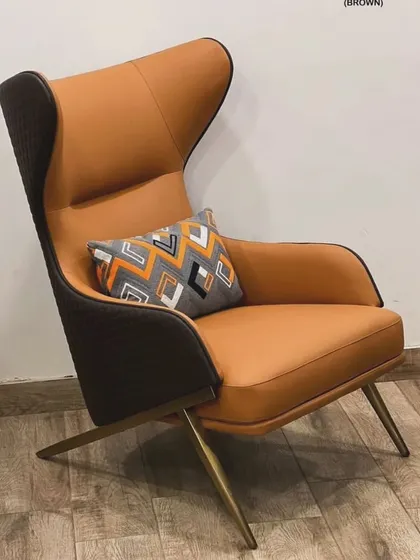A high-back lounge chair in a striking tan and dark brown dual-tone design. The quilted pattern on the back and sleek metal legs make it a luxurious addition to any space.