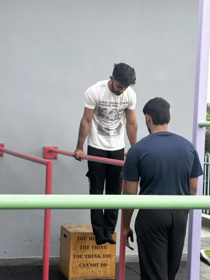 This is a duplicate of media ID 2. It reinforces our commitment to personalised coaching, showing a coach guiding a member through a dip, a fundamental calisthenics movement.