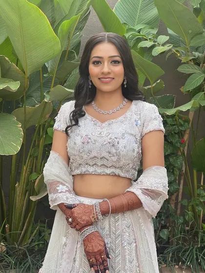 A happy engagement bride, showing off her complete look with a flawless makeup base and defined eyes.