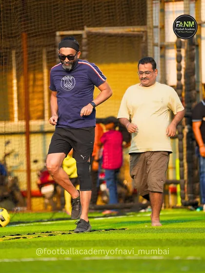 Two fathers jogging during a warm-up drill at our family football event. These sessions are a great way for parents to get a workout and share a healthy activity with the community.