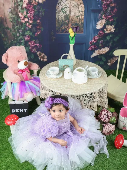 A whimsical tea party in an enchanted garden. This little girl in her lavender dress looks like she's stepped right out of a fairytale.
